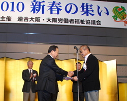 大阪労働者福祉協議会の山田理事長（前列右）に「大阪希望館」の寄付金が贈呈された。
