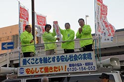 JR高槻駅前での集会でタスキを京都に引き継ぐため、タスキを受け取る多賀連合大阪事務局長（右から2人目）。集会には尾立民主党参議院議員（右から1人目）も駆け付けた