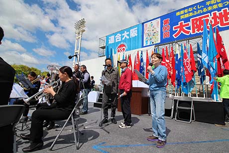 オープニングセレモニーで労働歌「晴れた五月」と「がんばろう」を合唱