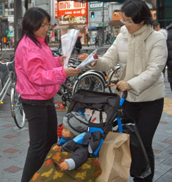 街行く人にバラを手渡す