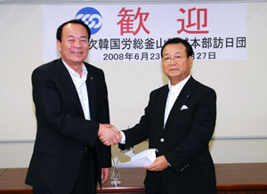 来年の訪韓での再会を誓って堅い握手を交わす李議長と川口連合大阪会長」