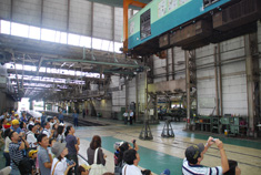 京阪電車の職員の説明を聞きながら工場内を見学する参加者