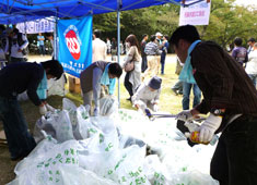 大阪南地域・泉州地区協議会では、黒鳥山公園周辺の清掃活動を行った。半日の清掃活動でかなりのゴミが集った。写真は、ゴミの集約所で分別の作業をする参加者。