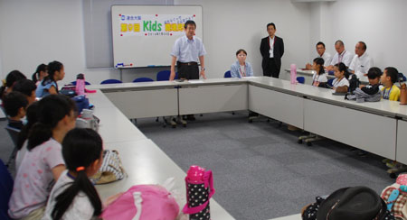 Kids職場見学会で働く現場を見て、いろんな体験をしてほしいとあいさつをする多賀事務局長